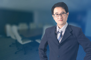 Double exposure of confident Asian businessman shaking hand in meeting room.