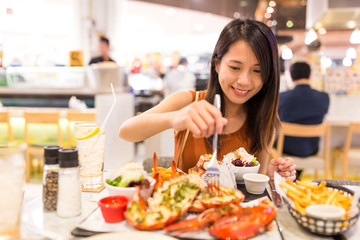 Woman enjoy her lobster in restaurant