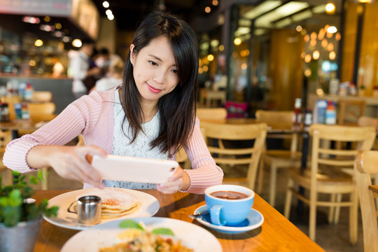 Woman taking photo on her dish before eating