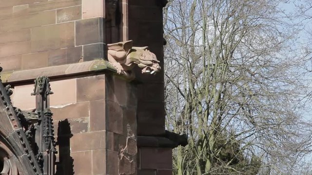 Ugly Gothic Gargoyle Dragon looms from the stone walls of Lichfield Cathedral 