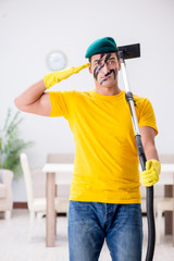 Funny man in military style cleaning the house
