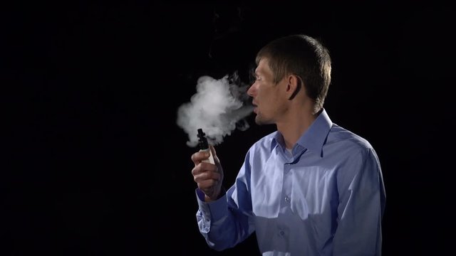 A man smokes an electronic cigarette