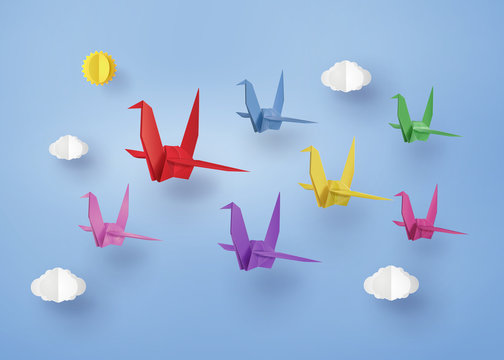 origami made colorful paper bird flying on blue sky with clound . paper art and craft style.