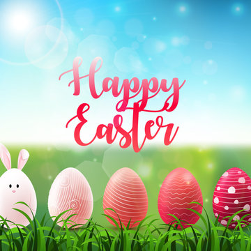 Easter background with colored easter eggs in the grass on sunny sky background