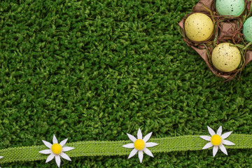 Naklejka premium Easter spring eggs with flowers dasies on green grass
