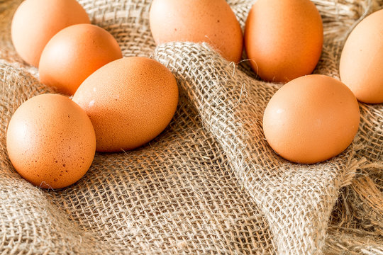 Fresh brown cage free eggs on burlap.