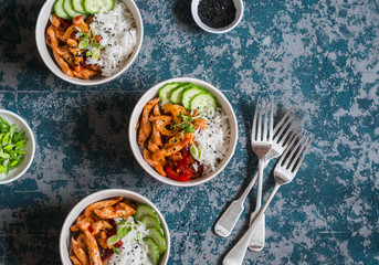 Asian style fried chicken and rice. Delicious lunch on a dark background, top view