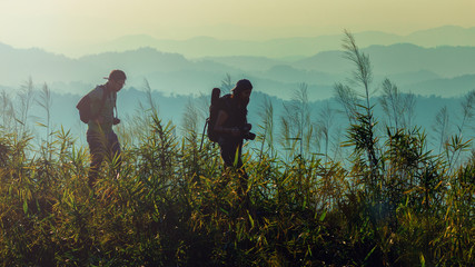  silhouette couple walking toward mountain summit with backpacks hiking trekking gear meeting...