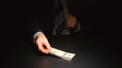 BRIBE: Businessman takes out a money from a pocket of a suit (US dollars)