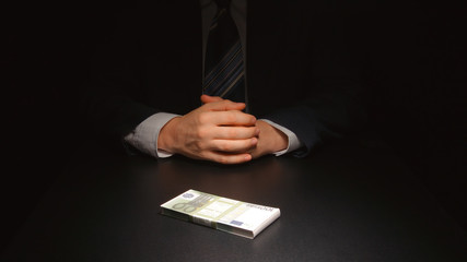 BRIBE: Businessman waits and puts a money on a table (EURO)
