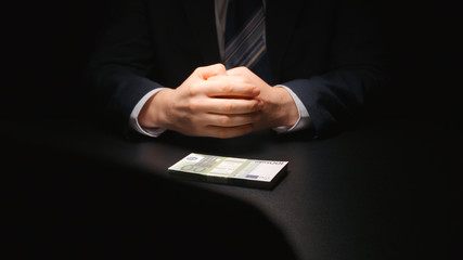 Bribe: Money between two businessmen on a table at negotiation time (euro)