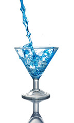 Splash in glass of a blue alcoholic cocktail drink