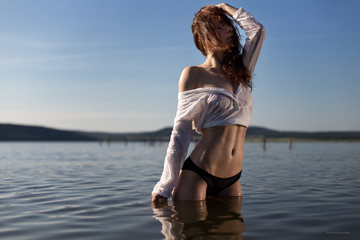 Young beautiful girl standing in water
