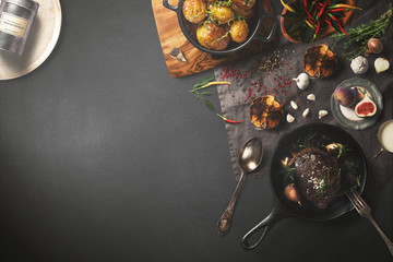 Overhead view of colorful roast vegetables, savory sauces and salt served with grilled t-bone steak on a rustic wooden counter in a country steakhouse created digital illustration