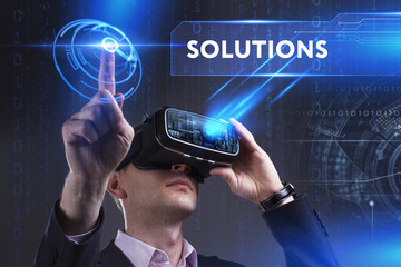 Business, Technology, Internet and network concept. Young businessman working in virtual reality glasses sees the inscription: Solutions