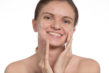 Beautiful young girl with red and white acne on her face. Before and after cream with sponge on a white background.