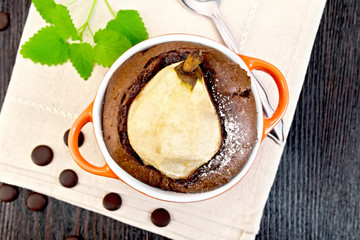 Cake chocolate with pear in red bowl on napkin top
