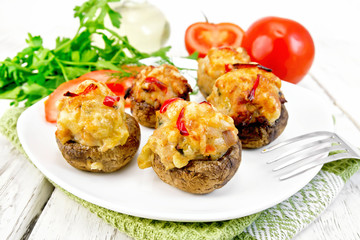 Champignons stuffed with meat and peppers in plate on napkin