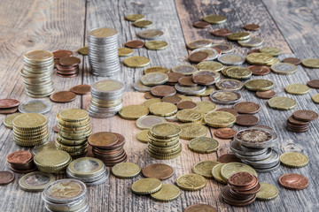 Money on the wooden table. Euro coin stocks from different countries.