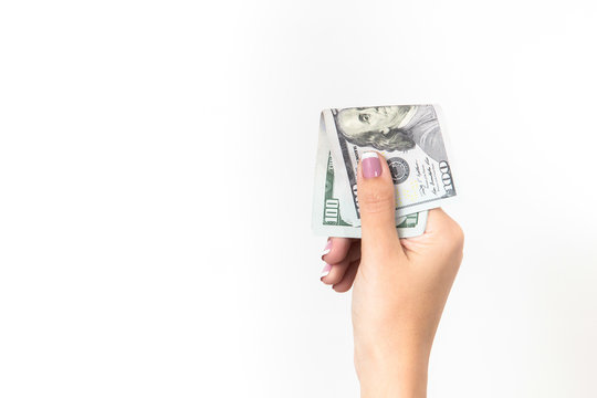 Closeup of one female caucasian hand holding many dollars isolated on white background. Horizontal color photo with copy space.