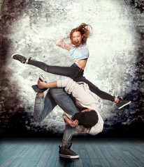 Couple break dancing on wall background