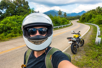 Island rider selfie wearing helmet and motorcycle in distance - Puerto Princesa, Palawan - Philippines