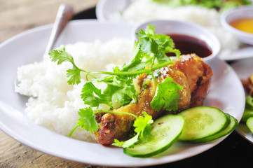 Vietnamese broken rice or com tam with fried chicken legs, pork and herbs