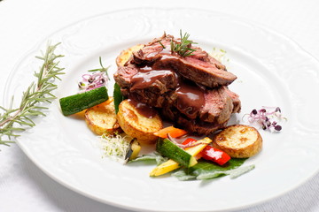 Grilled sliced roast beef on potato and salad