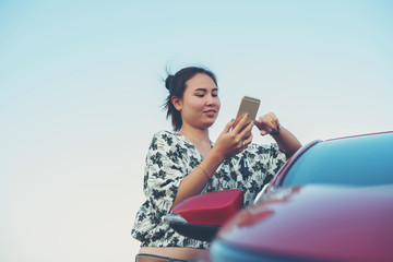 young woman playing mobile on the road
