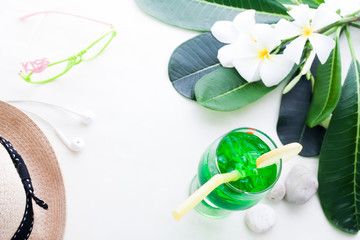 Iced green color drink on white background with plumeria flower, Summer concept with copy space