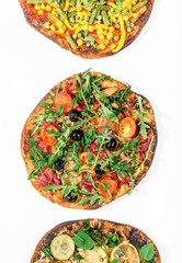 Three different vegan pizza on a white background