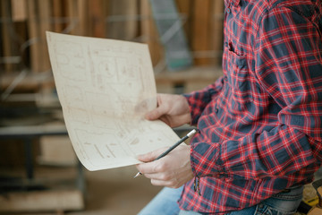 carpenter checking blueprint in workshop