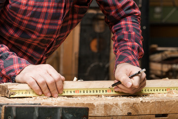 Man measuring wooden planks. Close-up.