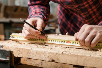 Man measuring wooden planks. Close-up.