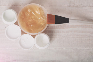 Cosmetic products on a wooden table in a beauty salon for a woman. White and shiny cream for the body. Cosmetics for skin care