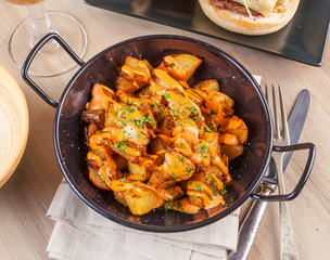 Patatas bravas, spicy potatoes, a typical Spanish dish with fried potato cubes and a spicy garlic sauce.