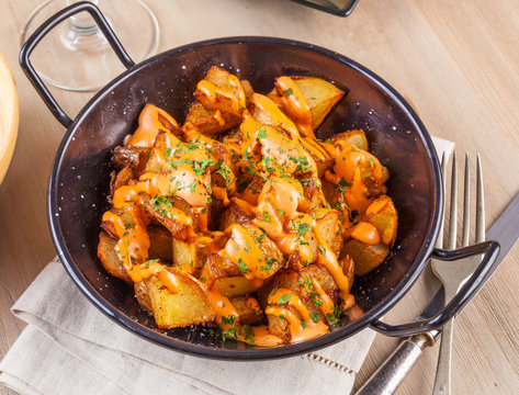 Patatas bravas, spicy potatoes, a typical Spanish dish with fried potato cubes and a spicy garlic sauce.