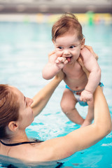 Fototapeta na wymiar Baby with mother in swimming pool
