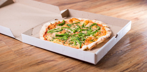 Italian pizza with green pepper in paper box tasty macro picture useful for background