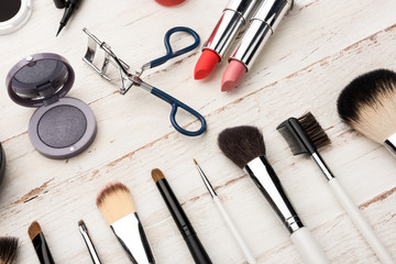 close up view of various brushes and cosmetics for applying makeup on table