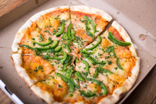 Italian pizza with green pepper in paper box tasty macro picture useful for background