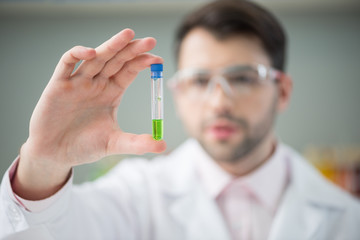 man scientist holding glass tube in hand in lab