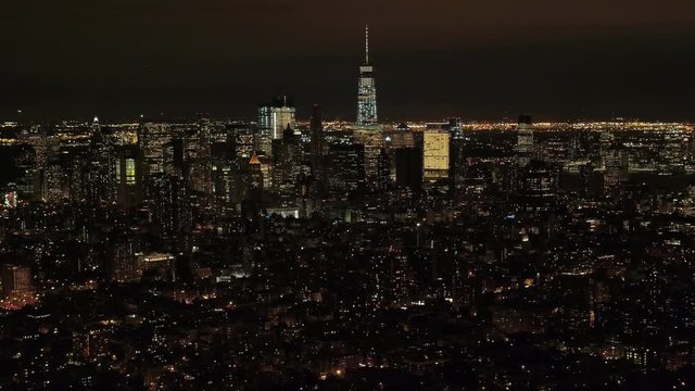 AERIAL HELI SHOT Flying above Midtown Manhattan residential area and Little Germany neighborhood looking toward downtown financial district & New Jersey in the background. City lights shining at night