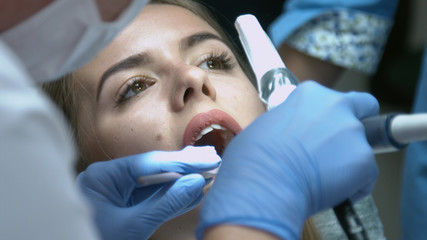 Beautiful girl on the examination by the doctor dentist