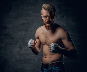 Brutal fighter with long hair over dark grey background.