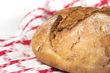 Selective focus baked bread isolated on red and white canvas