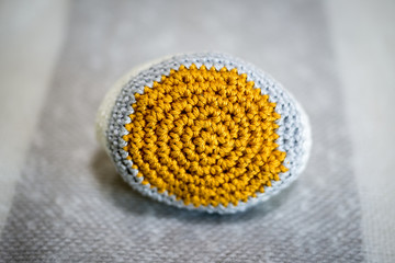 Ball of Crocheted White, Gray, and Gold-Colored Yarn