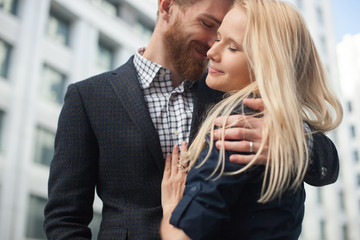 A young man embraces a girl in the city