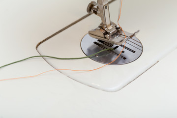 Sewing Machine Threaded with Green and Orange Thread