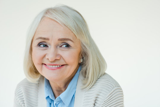 portrait of cheerful senior woman with makeup on white